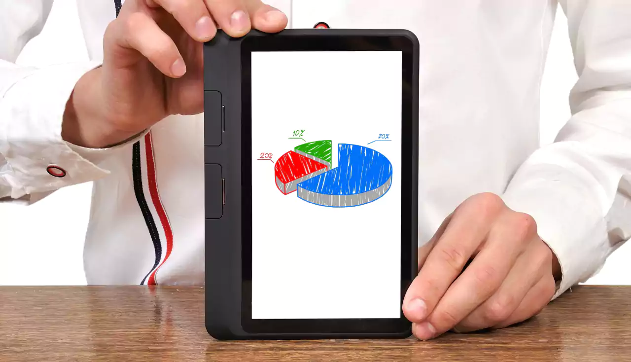 Male hands holding tablet device which displays pie chart
